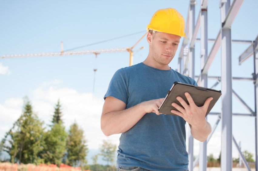 Construction worker reviewing plans on digital tablet Construction worker reviewing plans on digital tablet